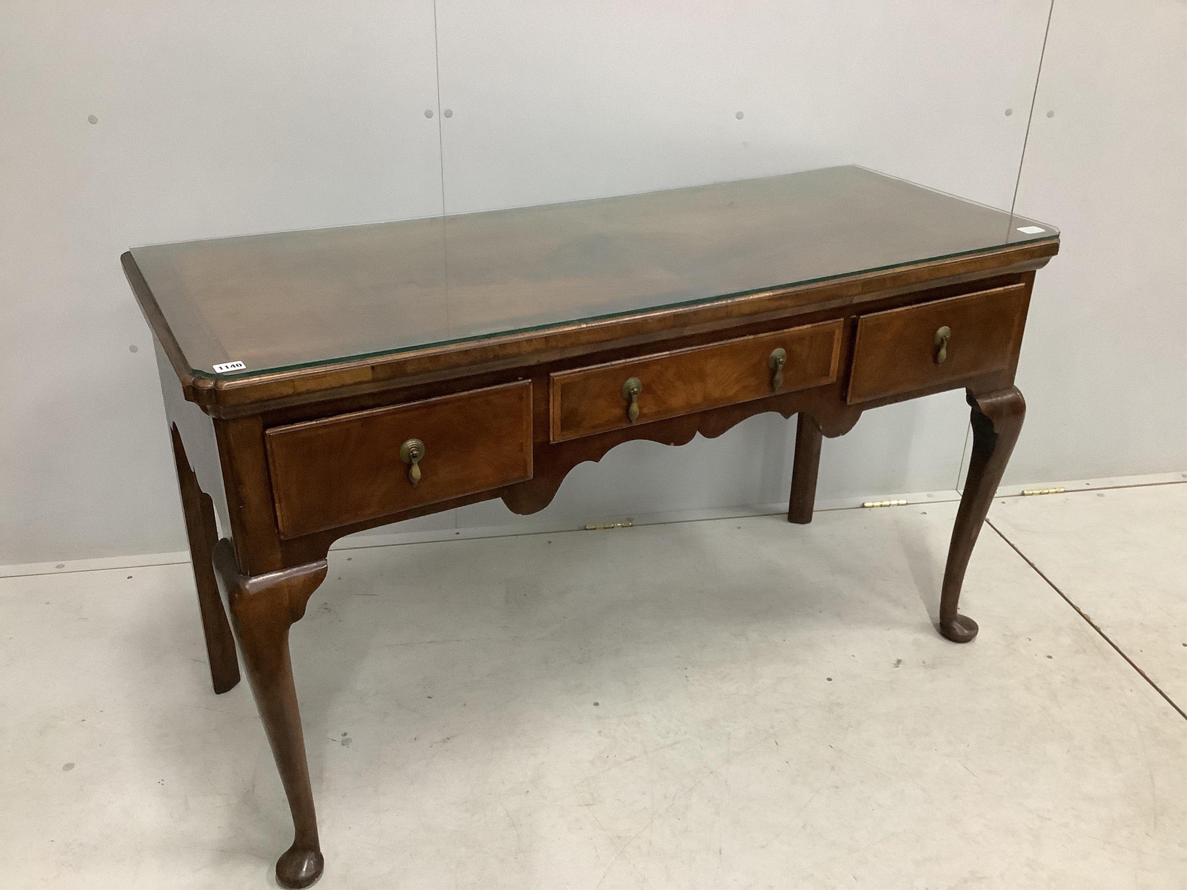 A George II style feather and cross banded walnut three drawer serving table, width 136cm, depth 53cm, height 80cm. Condition - fair